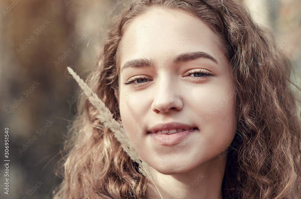 Portrait of beautiful happy girl smiling on her face with dry grass. Portrait of beautiful happy girl smiling on her face with dry grass.