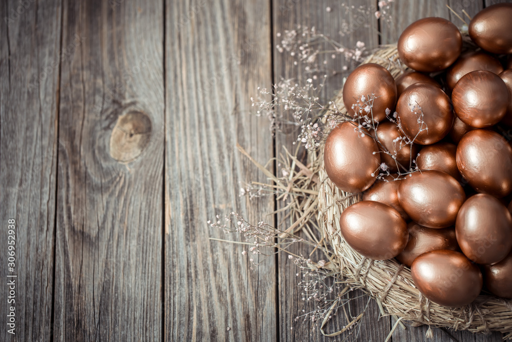 Background with Golden Easter eggs on wooden background.