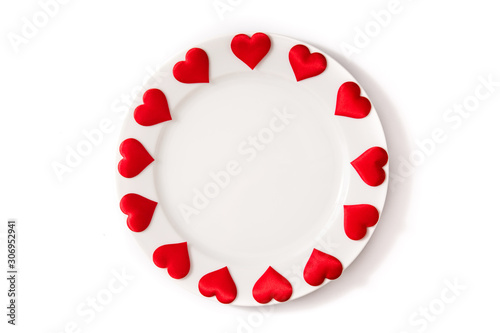 White plate surrounded by hearts on white background photo