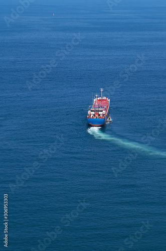 Barco carguero abandonando el puerto y describiendo una curva en su trayectoria