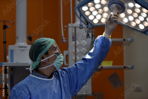 Medical Team Performing Surgical Operation in Modern Operating Room. Equipment and medical devices in hybrid operating room.scrub nurse preparing medical instruments for operation.