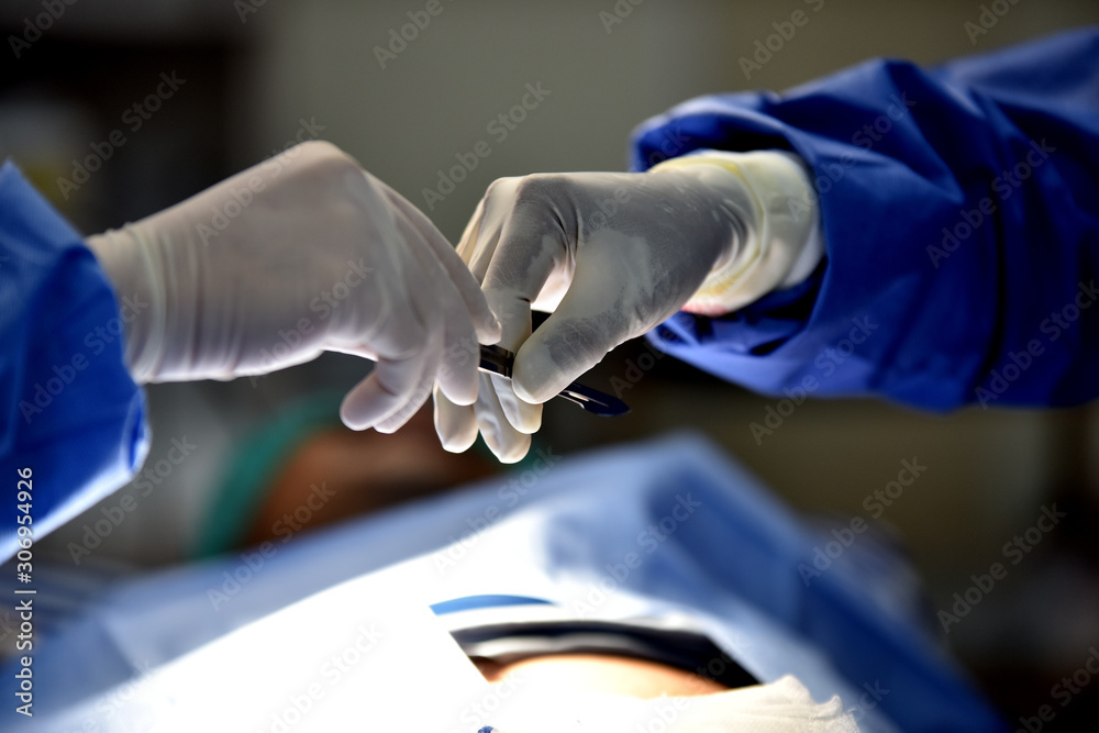 Medical Team Performing Surgical Operation in Modern Operating Room. Equipment and medical devices in hybrid operating room.scrub nurse preparing medical instruments for operation.