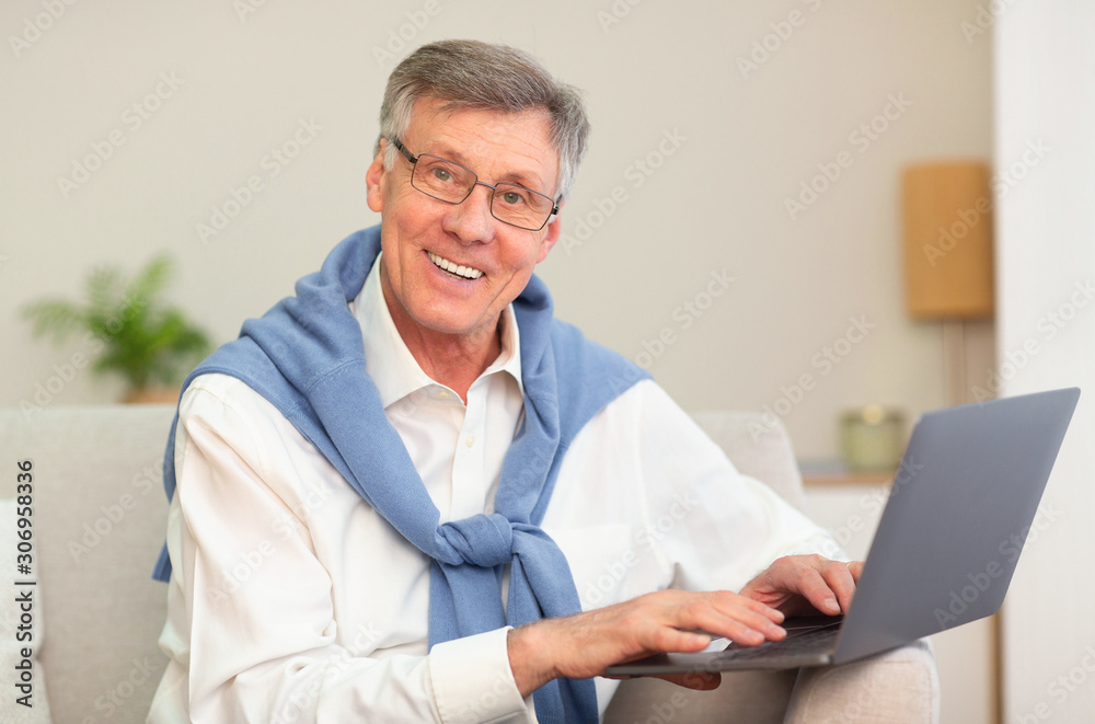 Senior Gentleman Using Laptop Smiling Sitting On Sofa Indoor Senior Gentleman Using Laptop Smiling Sitting On Sofa Indoor