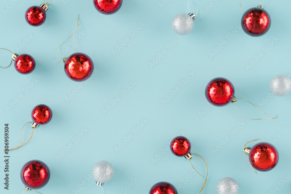 Heap of red and silvery Xmas balls decoration on light blue background. Flat lay composition for Christmas with Christmas balls decoration in different textures and copy space. Heap of red and silvery Xmas balls decoration on light blue background. Flat lay composition for Christmas with Christmas balls decoration in different textures and copy space.