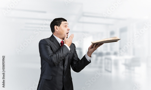 Scared businessman covering mouth with hand