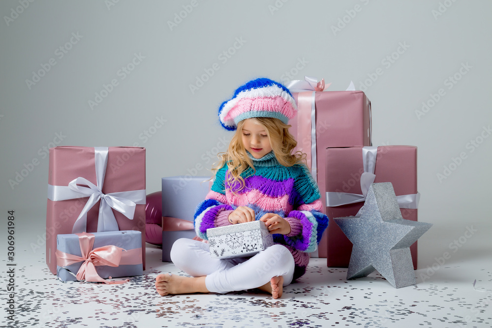 little blonde girl smiling holding gift box on light background, holiday concept, space for text little blonde girl smiling holding gift box on light background, holiday concept, space for text