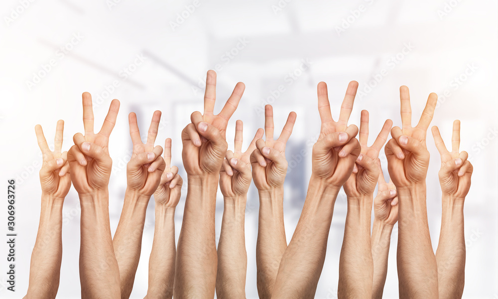 Row of man hands showing victory gesture Row of man hands showing victory gesture
