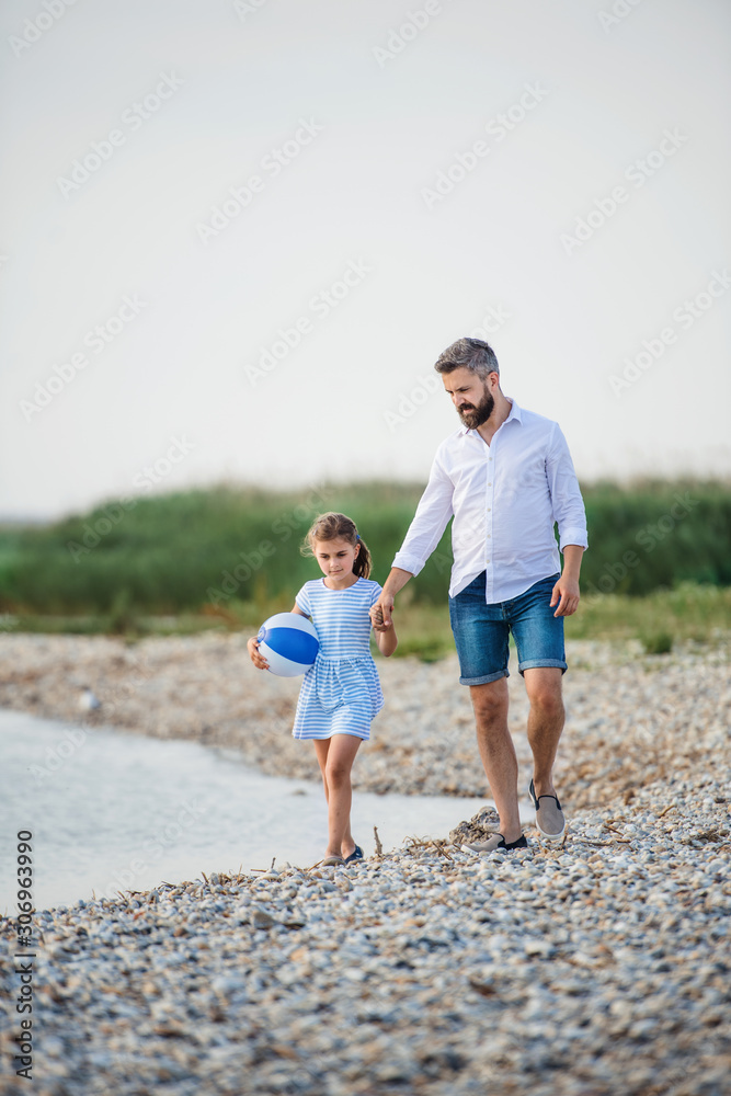 Mature father and small daughter on a holiday walking by the lake. Mature father and small daughter on a holiday walking by the lake.