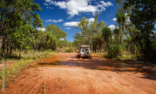 Cuadro en lienzo Western Australia – Flooded Outback gravel road with 4WD car crossing the waterh