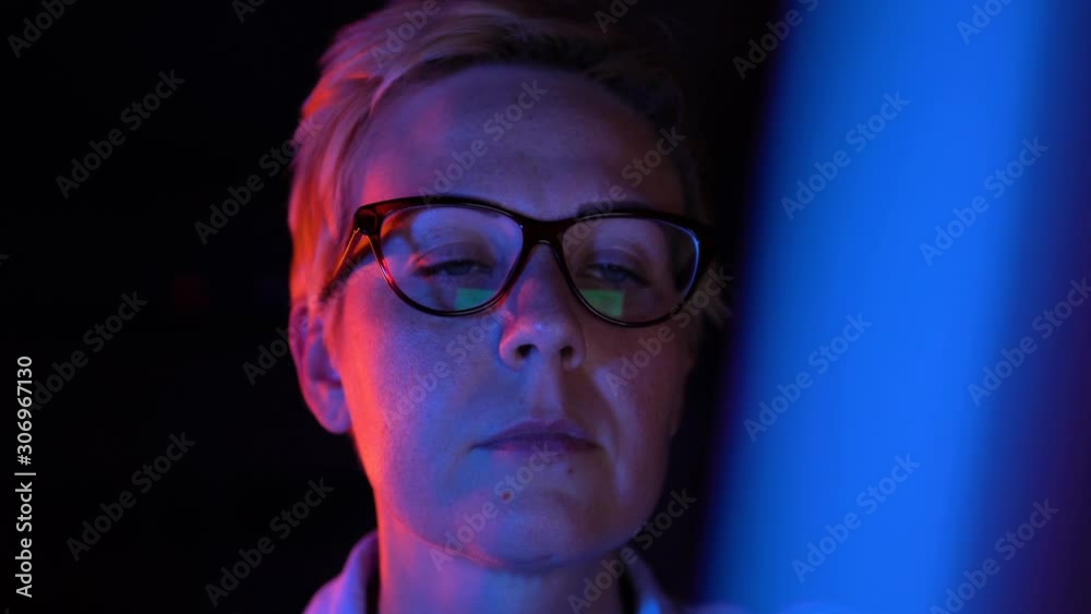 Ready to start! Strong woman doing important task at night, neon lighted office Ready to start! Strong woman doing important task at night, neon lighted office