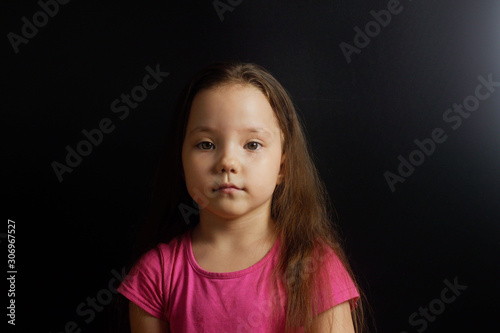 Portrait of a little girl on a black background