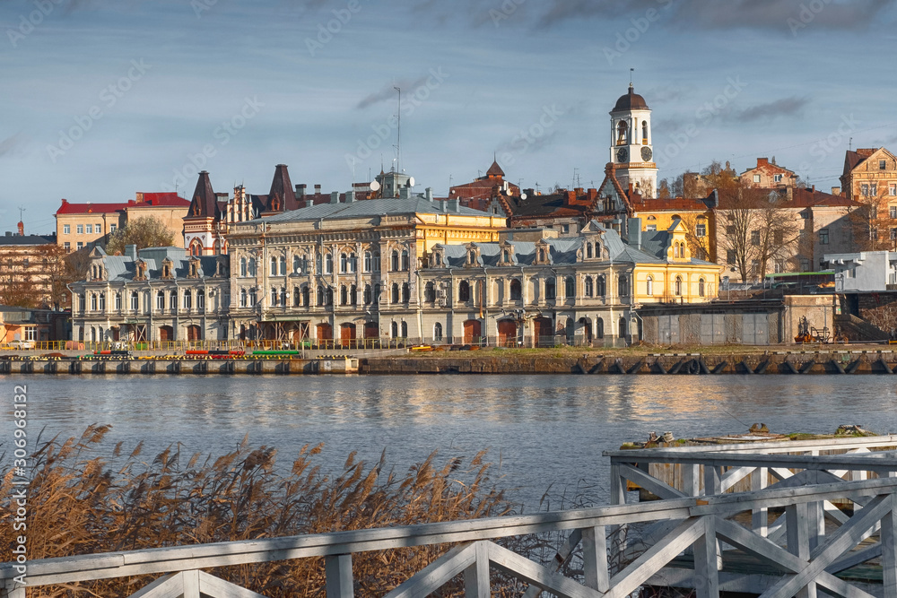 Obraz premium Panorama of the embankment with ancient beautiful buildings of the city of the middle-century city of Vyborg in Russia on an autumn sunny day