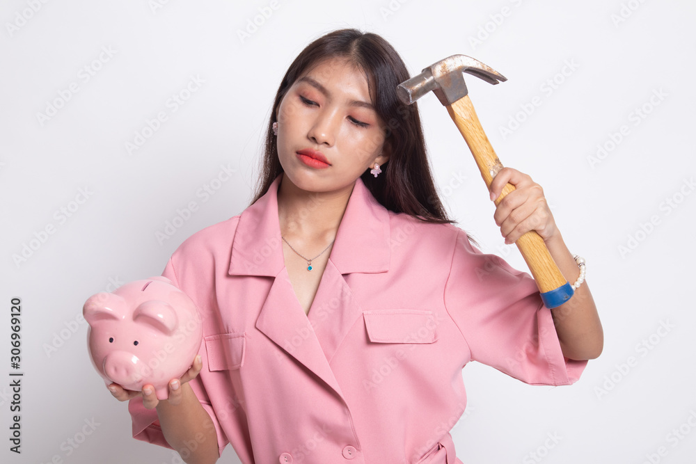 Asian woman with pig coin bank and hammer. Asian woman with pig coin bank and hammer.