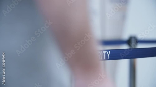 Close-up text security on blue tape barrier at airport. People with travel bags go to customs inspection before boarding an airplane