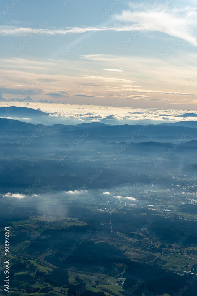 Blick aus dem Flugzeug über Wolken und Berge 