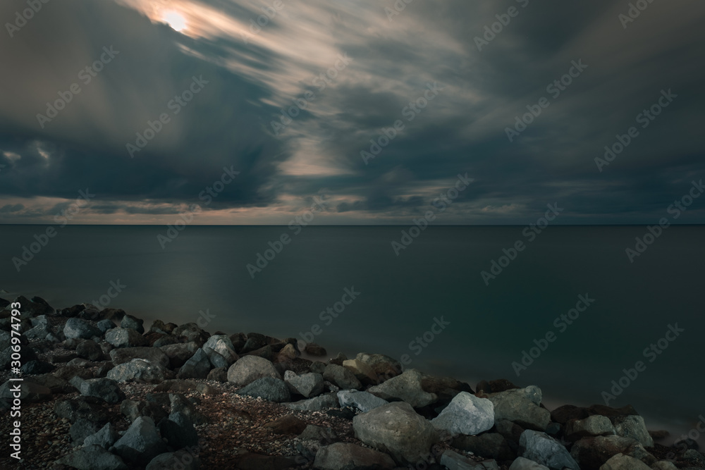 Long exposure shot. Sea scape with stone beach at sunset, Motion blur, slow shutter speed Long exposure shot. Sea scape with stone beach at sunset, Motion blur, slow shutter speed