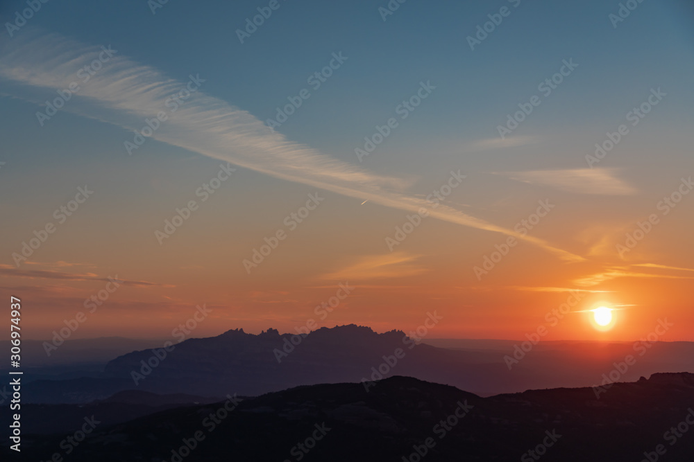 Views at sunset of Montserrat silhouette with blue and orange sky in Catalonia, Spain