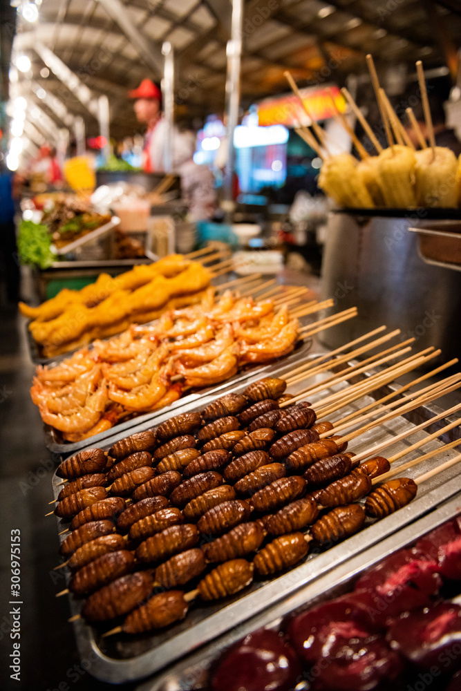 Obraz premium Grill and fried silkworm pupae in a food market in Beijing, China.