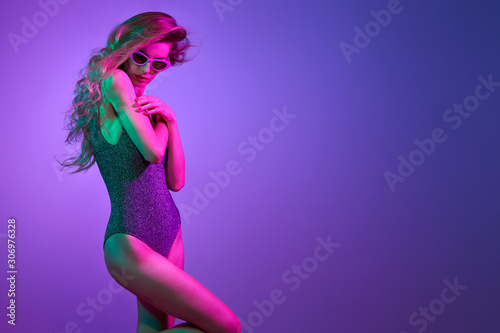 High Fashion. Party disco girl with pink neon hairstyle dance. Sensual beautiful woman in Colorful uv Light. Vibrant fashionable creative Style. Night Club music vibes, dancing, neon lighting color
