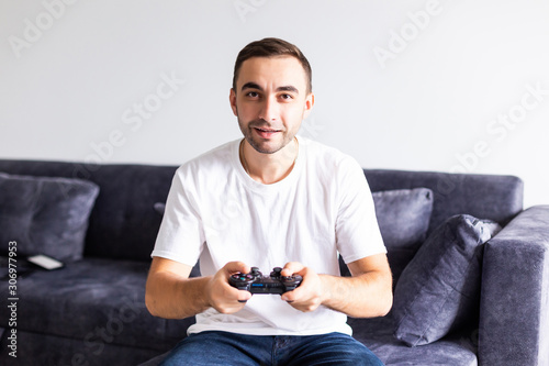 Young happy man laughing and playing video games on weekend