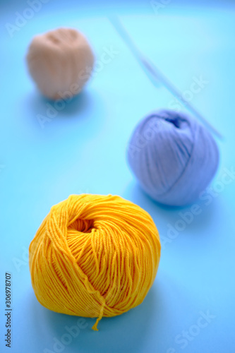 Bright color yarn clews on the blue background. Concept of amigurumi toy making, handicraft, knitting, hobbie
