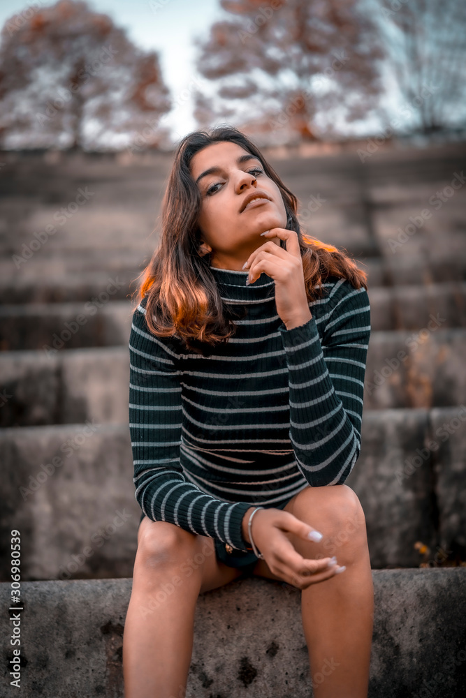 Lifestyle, a young serious brunette sitting in the amphitheater of San Sebastian