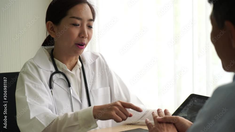 Asian doctor and patient are discussing something Asian doctor and patient are discussing something