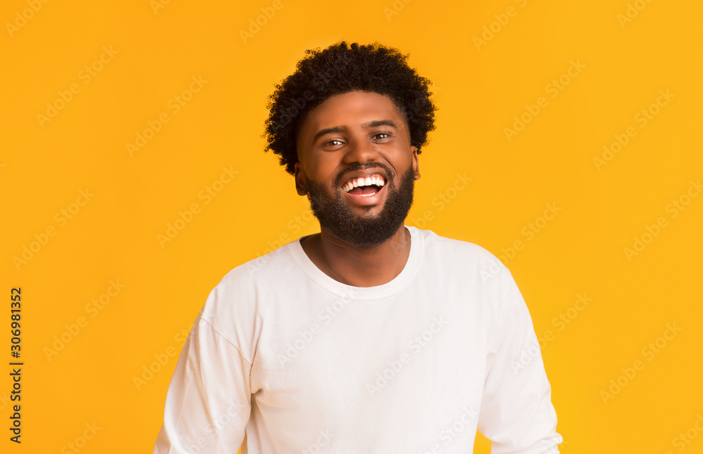 Joyful african american guy over orange background Joyful african american guy over orange background