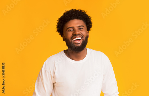 Joyful african american guy over orange background