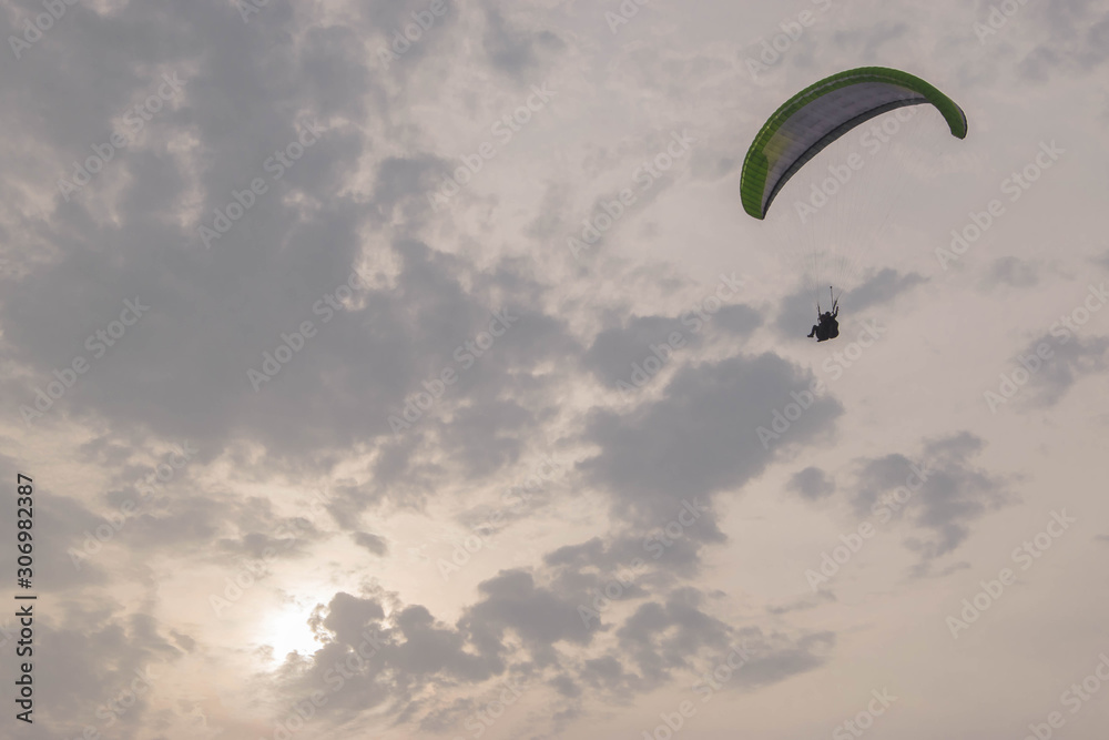 green paragliding in the cloudy sky
