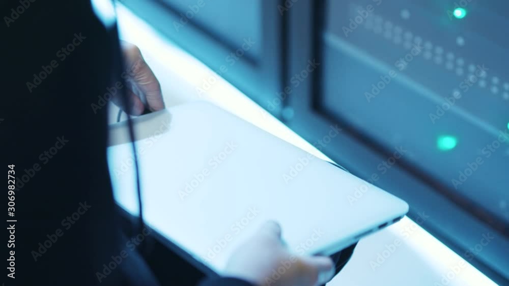 Close-up professional hacker coding on laptop showing access granted on monitor. Successful spy team breaking into supercomputer at server room of data center. Close-up professional hacker coding on laptop showing access granted on monitor. Successful spy team breaking into supercomputer at server room of data center.