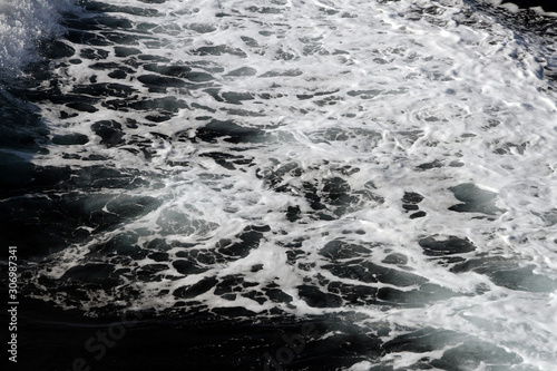 Weisser Schaum und Wellen auf der Wasseroberfläche im Meer. Gischt am Ozean bei einer Fahrt mit dem Schiff. Wasser in Bewegung. Hintergrund