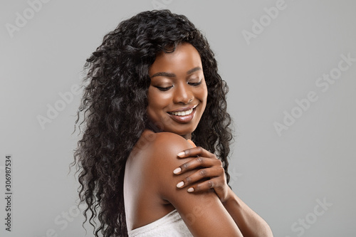 Beautiful afro girl touching her soft skin on body