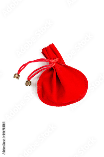 Small red velvet pouch for jewelry on a white background. Gift and holidays concept. Copy space. Flat lay, top view