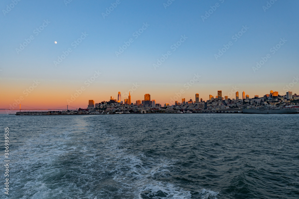 Gold sunset over San Francisco Bay with full moon and birds