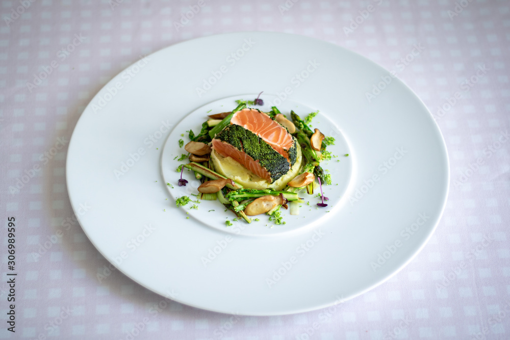 Salmon with Dill  and Sauteed Vegetables served on white plate over white texture background. Top view, copy space. Plating, fine dining