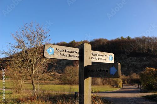 A signpost between Butser Hill and Queen Elizabeth Country Park in Hampshire pointing to the South Downs Way, a long distance footpath and bridleway running along the South Downs in southern England. photo