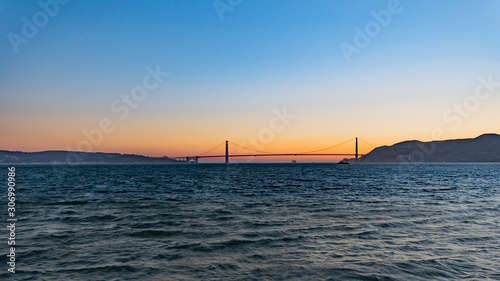 Gold sunset over San Francisco Bay with full moon and birds