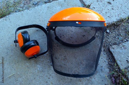 Photography tree surgeon tools on desk including chainsaw, helmet, harness, ear defenders an