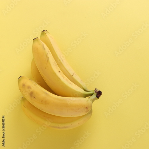 Sweet bananas on punchy pastel yellow background, Top view