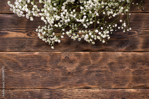 Gypsophila flower plant on brown wooden table background.
