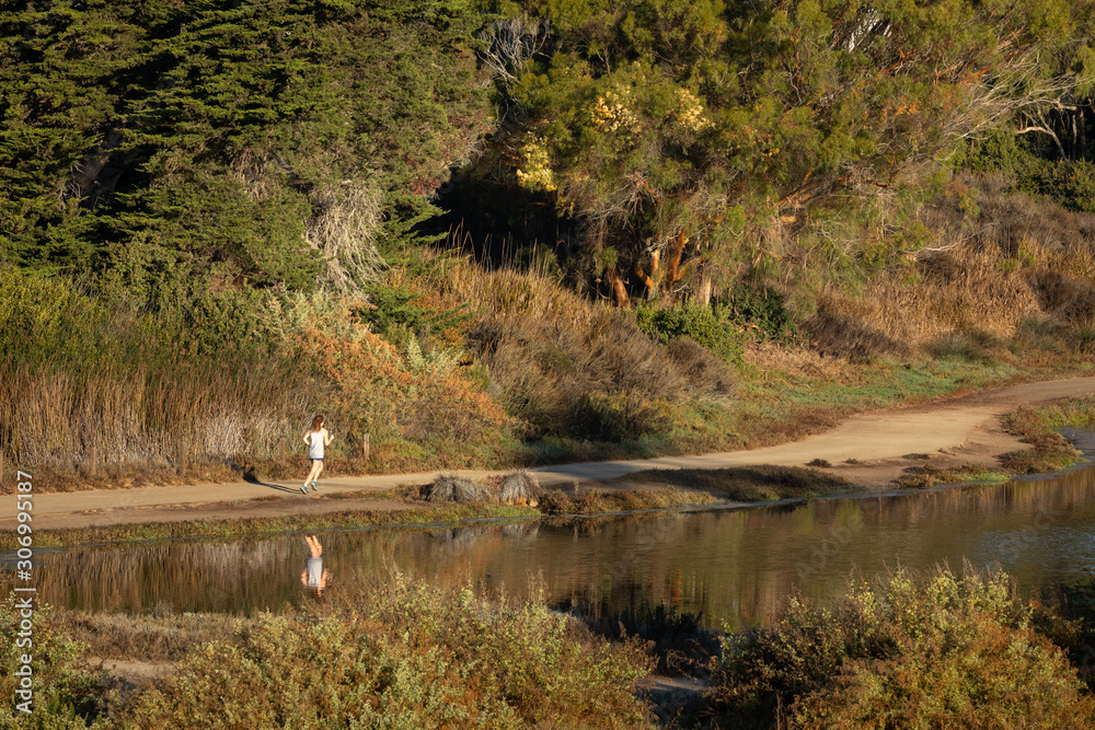 Jogger running along a lake shore Jogger running along a lake shore
