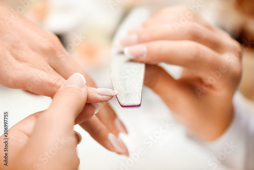 Perfect nails manicure with file or brushing details. Woman beautiful nail care in salon.