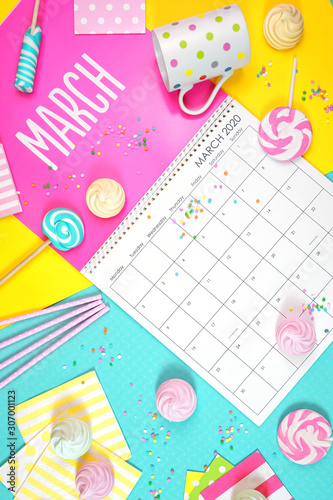On-trend 2020 calendar page for the month of March modern flat lay with seasonal food, candy and colorful decorations in popular pastel colors. Vertical. One of a series for 12 months of the year.