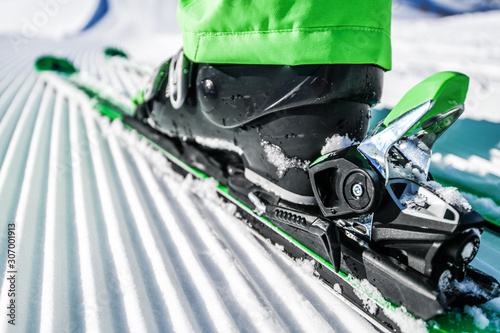 New groomed piste or slope. Lines in snow. Winter skis and detailed view of the ski bindings concept.