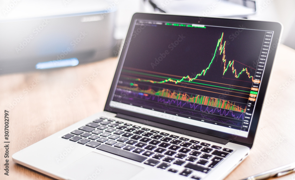 Modern laptop with financial bitcoin cryptocurrency crypto graph data trade. Computer notebook workplace detail.