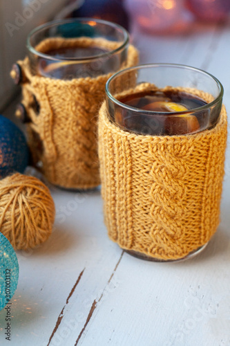 Two cups of delicious tea in yellow knitted sweater.