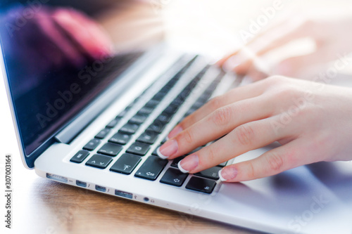 Woman working on modern computer. Person buying online at internet. Laptop keyboard detail with hands.