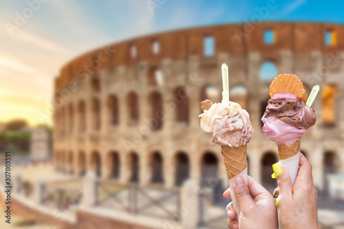 Colosseum at sunset in Rome, Italy with italian ice cream gelato in hands. World famous landmark in Italy