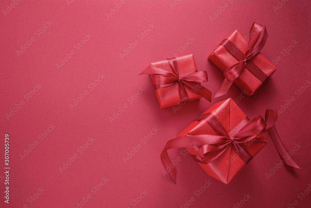 Red gift boxes isolated on red background with red bow. Top view. Copy space. Christmas, Party or Valentin's Day concept. Red gift boxes isolated on red background with red bow. Top view. Copy space. Christmas, Party or Valentin's Day concept.